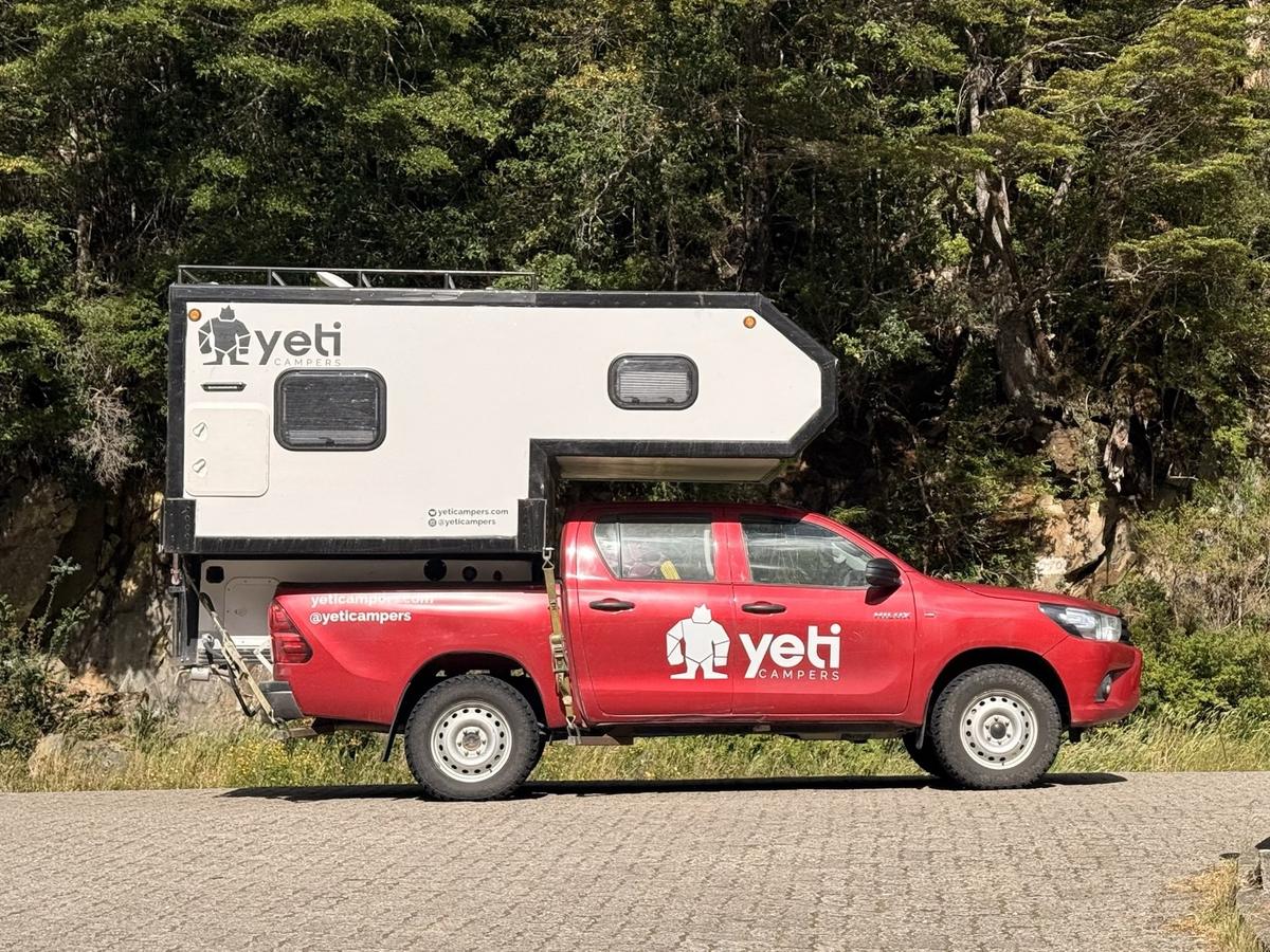The Nomad Camper, a Toyota Hilux 4×4 with its camper cabin, parked by a forest road