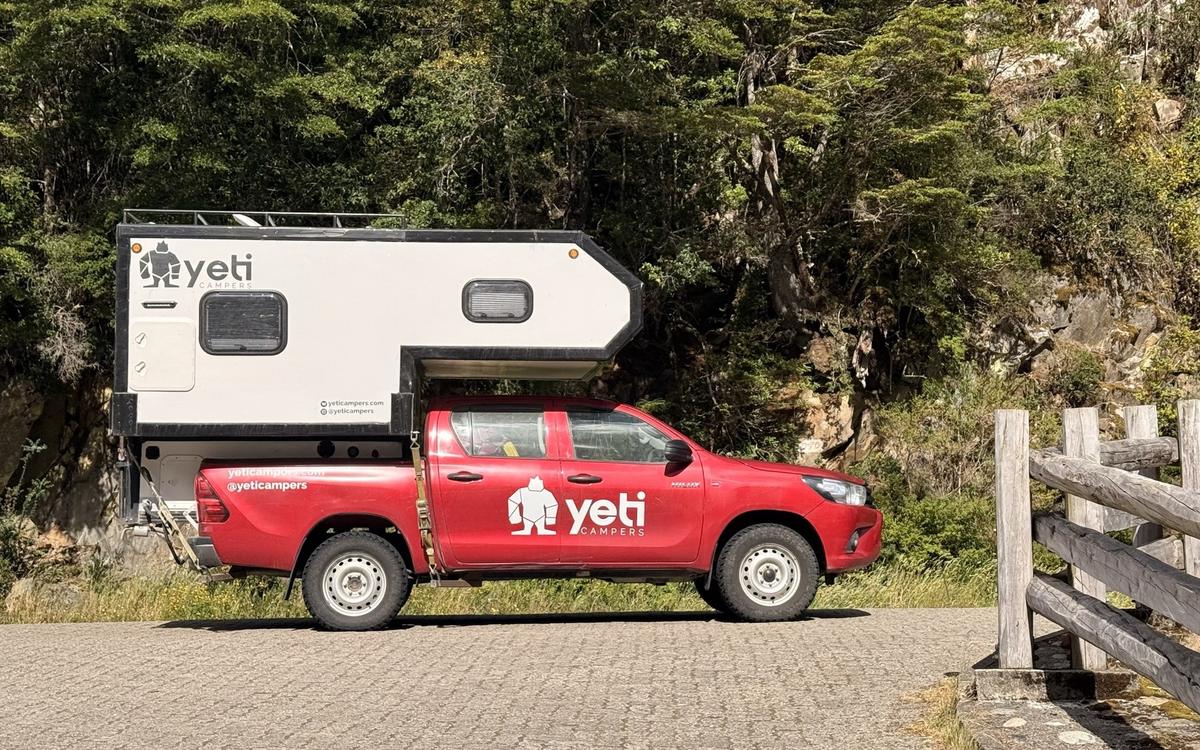 The Nomad Camper, a Toyota Hilux 4×4 with its camper cabin, parked by a forest road